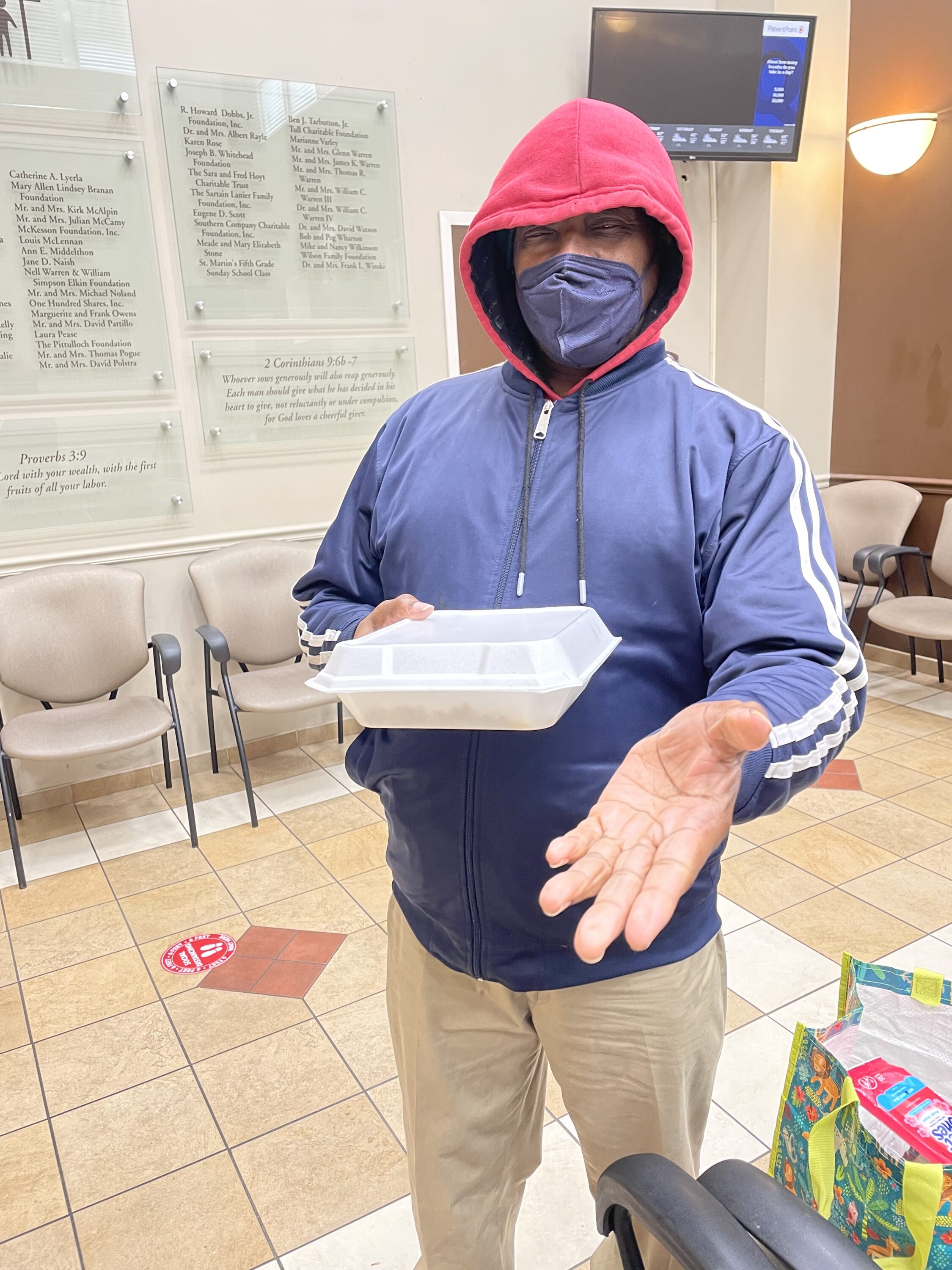 Good Sam Friday Patient receiving a meal and Hygiene Kit with Care Package containing donations from Whole Foods, Gus’s Fried Chicken and other partners.